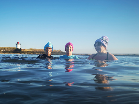 Burry Port, Wales, UK: January 13, 2022: A group of mature female friends swimming in the sea. The Bluetits Chill Swimmers Ltd is a social enterprise committed to empowering our inclusive community of outdoor swimmers.