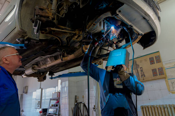 manager and welding man under the car - car bodywork flash imagens e fotografias de stock