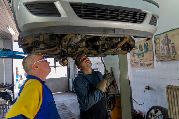 manager et soudeur sous la voiture - car bodywork flash photos et images de collection