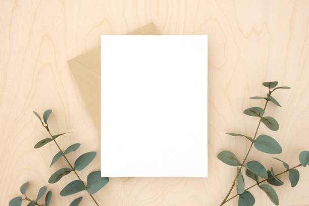 istock Blank greeting card, invitation mockup. Eucalyptus branches plant on wooden table background. Flat lay, top view. Copy space. Canvas mock up. Modern Minimal business brand template. Soft shadow. 1402311765