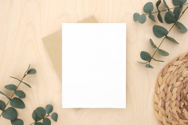 istock Blank greeting card, invitation mockup. Eucalyptus branches plant on wooden table background. Flat lay, top view. Copy space. Canvas mock up. Modern Minimal business brand template. Soft shadow. 1402311782