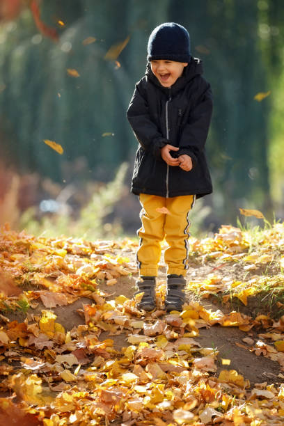istock Happy kid having fun in autumn forest or park on fall day. 1402313002