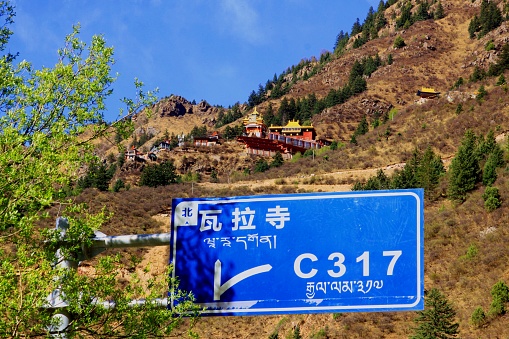 The Chinese characters on the road sign read: Wara Temple.National Highway 317, is parallel to national Highway 318 east-west road in and out of northern Tibet. Along the thousands of kilometers of highway, there is a strong religious atmosphere and traces. Tourists are rare. Photo in Chamdo(Qamdo) area