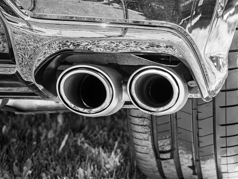 Monochrome close up picture with a double exhaust pipe.