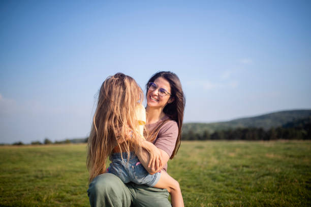 istock A smiling mother enjoys her daughter's embrace. 1402320076