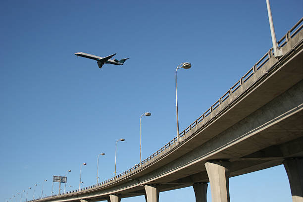 Airplane over highway stock photo