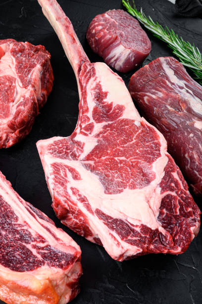 istock Raw Black Angus Prime meat steaks, Tomahawk cut, on black stone background 1402322099