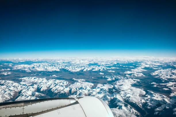 Airplane Wing in Flight above the mountain stock photo