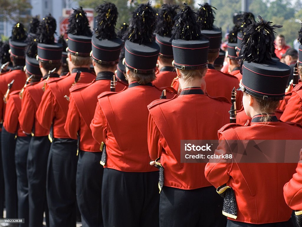 College marching band in formation US College marching band in formation with red uniforms and black pants and hats, prior to football game. Marching Band Stock Photo