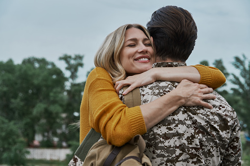 Happy woman hugging her husband after his returning home from the army