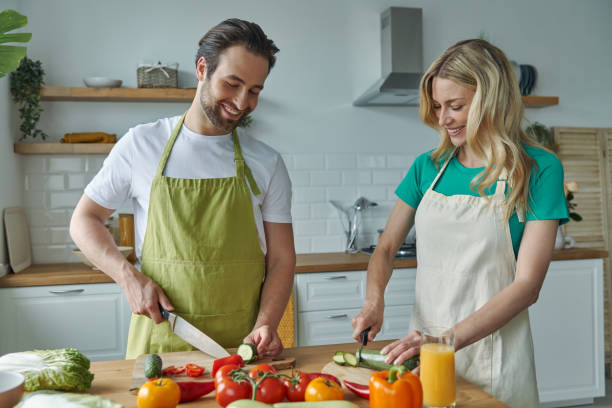 istock Cheerful young couple chopping vegetables at the domestic kitchen 1402329961