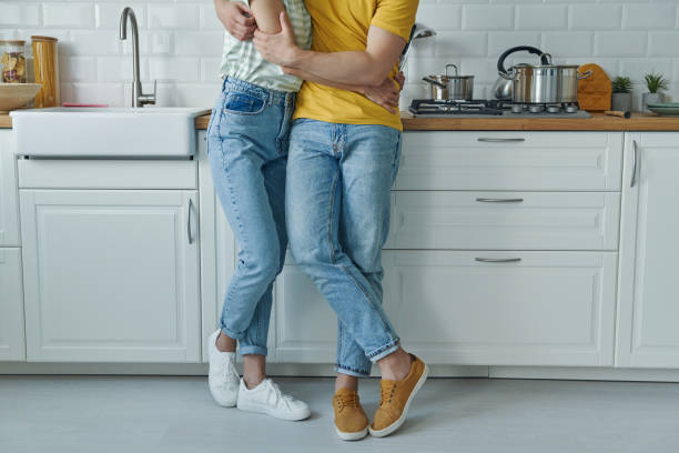 istock Close-up of couple embracing while standing at the kitchen 1402332874