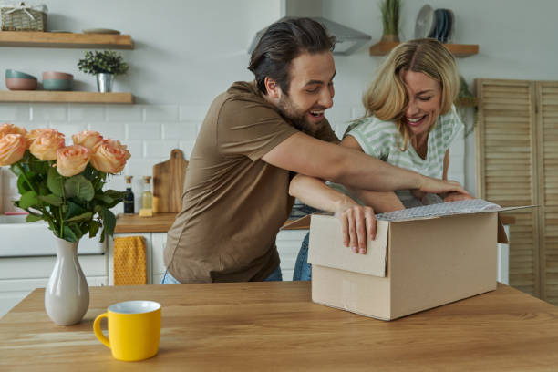 istock Playful young couple unpacking box together 1402332891