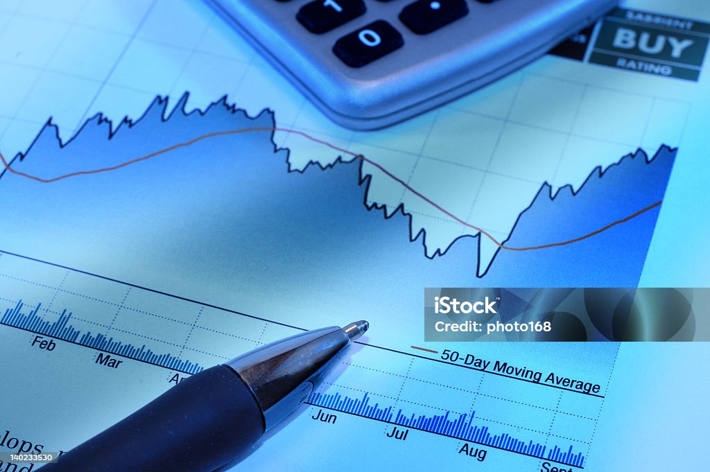 stock market investment charts pen calculator stock chart with pen and calculator Analyzing Stock Photo