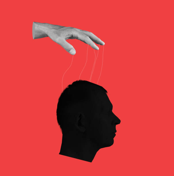Control over human mind. Hand with strings and head on red background. Manipulation of person consciousness, thoughts, opinion.