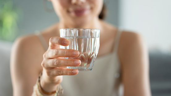 Young woman drinks a glass of water