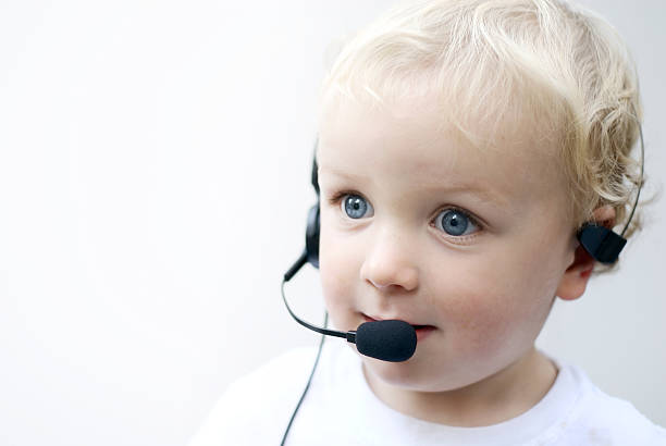 Young boy wearing phone headset Young toddler boy wearing headset for call center and customer service noah young stock pictures, royalty-free photos & images