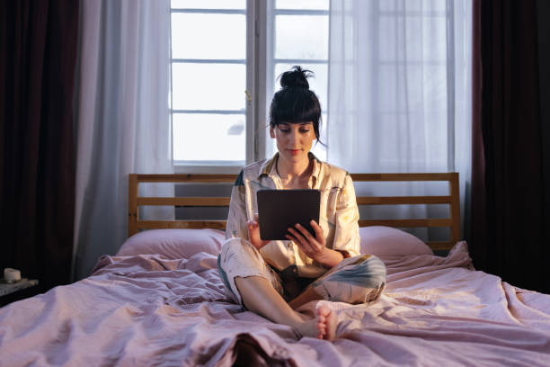 istock Caucasian Woman Using Her Tablet Device In Bed 1402344929