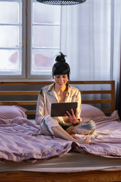 istock Caucasian Woman Using Her Tablet Device In Bed 1402344930