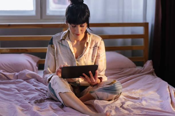 istock Caucasian Woman Using Her Tablet Device In Bed 1402344936