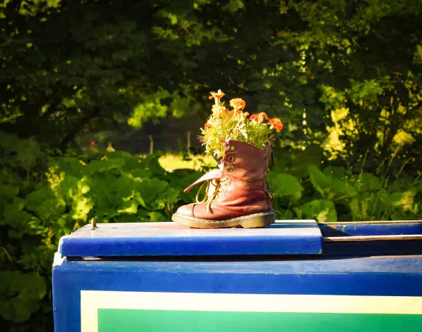 A Boot Plantpot rests on top of the hatch of a canal boat.
