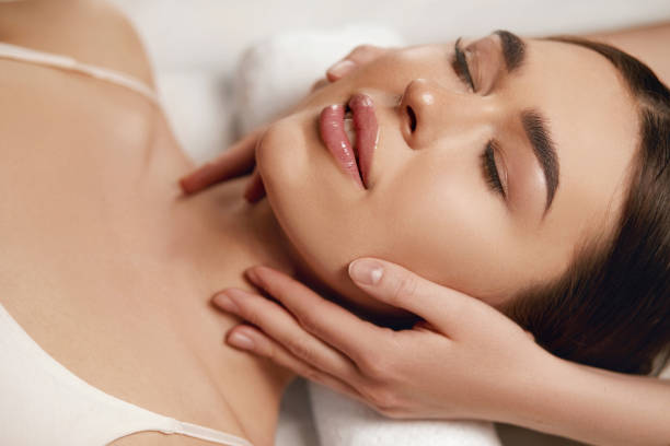 Face massage. Beautiful of young woman getting spa massage treatment at beauty spa salon.Spa skin and body care. Facial beauty treatment.Cosmetology. stock photo