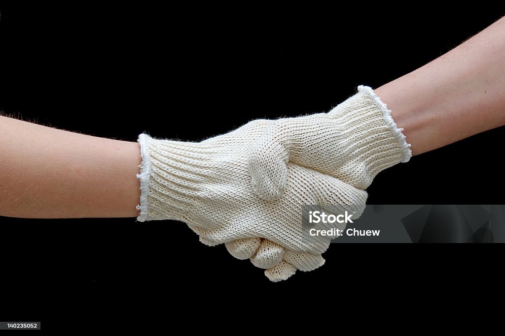 Labor handshake with safety gloves isolated on black Please, see another my gloves images Black Color Stock Photo