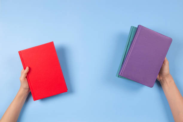 istock Hands holding books over light blue background. Education, self-learning, book swap, sharing, bookcrossing concept 1402351206