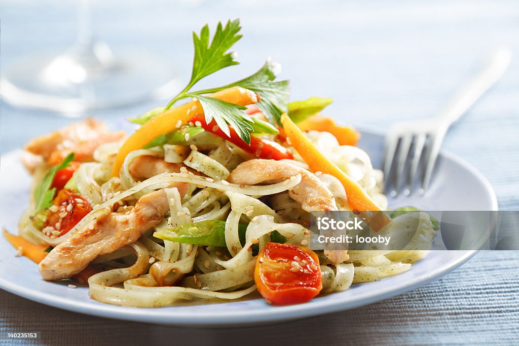 noodles stirfry rice noodles with chicken or turkey ,cherry tomato, carrot, red pepper,green beans, parsley and sesame seeds Pasta Stock Photo