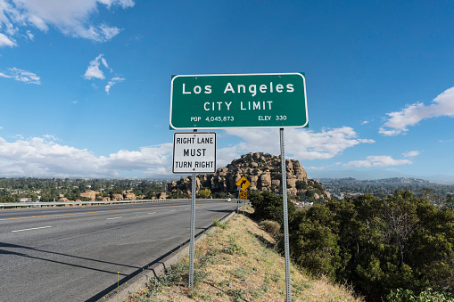 Los Angeles city limit sign on Topanga Canyon Blvd - State Route 27 in Chatsworth, California.  Stoney Point park is in background.