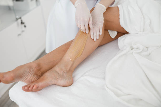 istock Woman client having hair removal procedure on leg using sugaring paste in beauty salon 1402356905