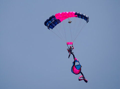 Hillsboro, Oregon, USA - May 22, 2022 :  Misty Blues, an all women skydiving team member close to the ground. The Air Show in Hillsboro, Oregon is a very popular event each year. The theme for 2022 was “She Flies with her own wings.” All performers, pilots and announcers were women. Hillsboro is a suburb of the city of Portland, Oregon.