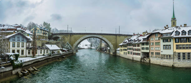 nydeggbrucke bridge and swiss buildings on both sides of river aare during snowfall in bern, switzerland - berne berne canton aare river switzerland imagens e fotografias de stock