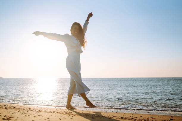 istock Young woman walks along the seashore. 1402361247