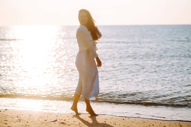 istock Young woman walks along the seashore. 1402361251