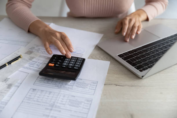 istock Close up woman calculating bills, using calculator and laptop 1402361667