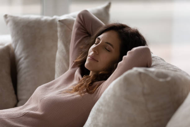 istock Close up peaceful woman with closed eyes resting on couch 1402361692