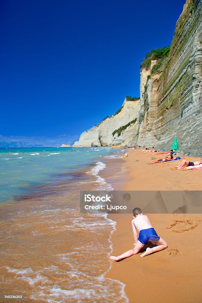 Criança brincando na praia na ilha de Corfu - Foto de stock de Areia royalty-free