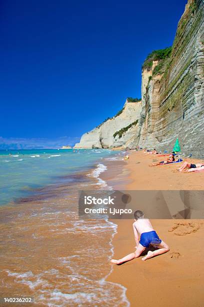 Foto de Criança Brincando Na Praia Na Ilha De Corfu e mais fotos de stock de Areia - Areia, Atividade, Azul