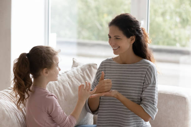 istock Smiling caring mother teaching disabled daughter, learning sign gesture 1402362316