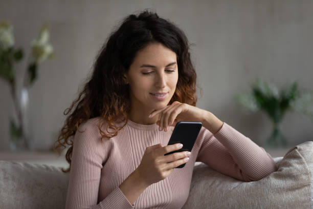 istock Head shot smiling woman looking at smartphone screen, chatting online 1402362437