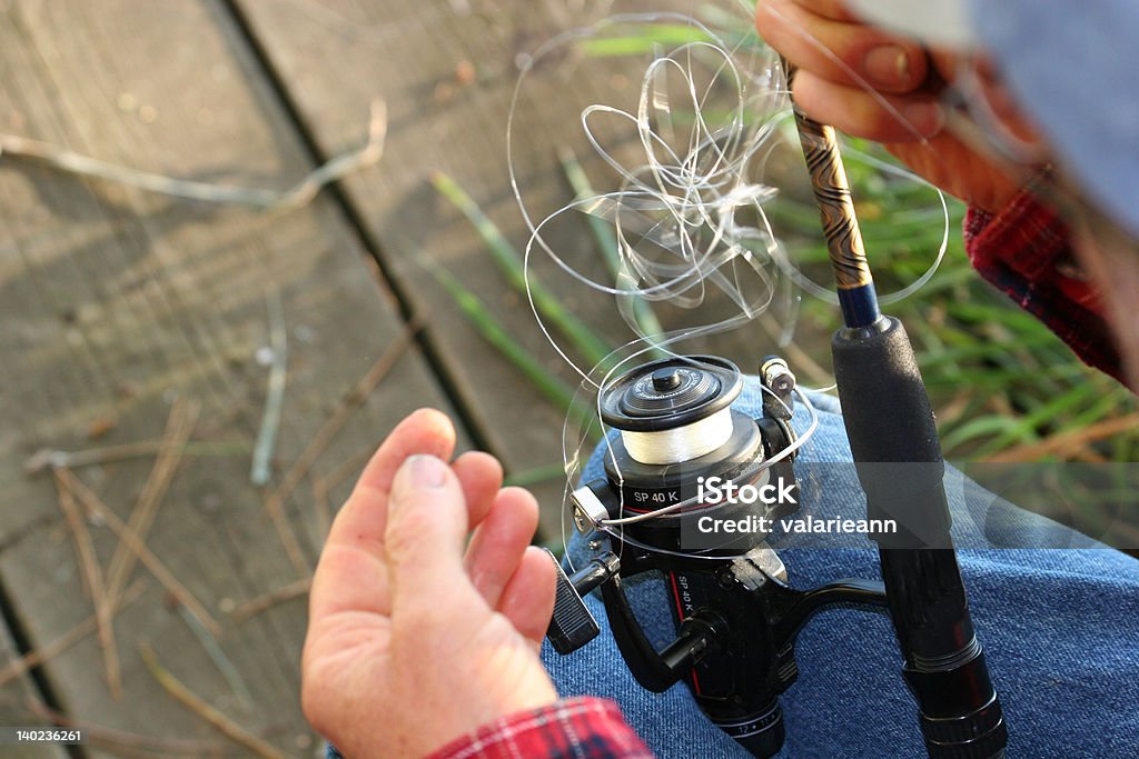 Fishing frustration Fisherman trying to untangle fishing line. Tangled Stock Photo