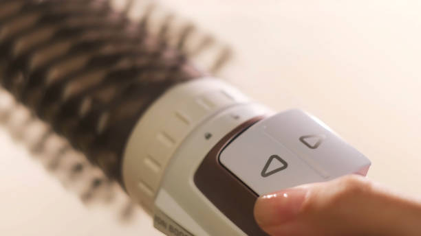 nahaufnahme des rotierenden heißluftfriseurs in weiblichen händen. begriff. weibliche hände, die die arbeit des lufttrockners isoliert auf weißem hintergrund zeigen, konzept der schönheit. - electric fan women wind beautiful stock-fotos und bilder