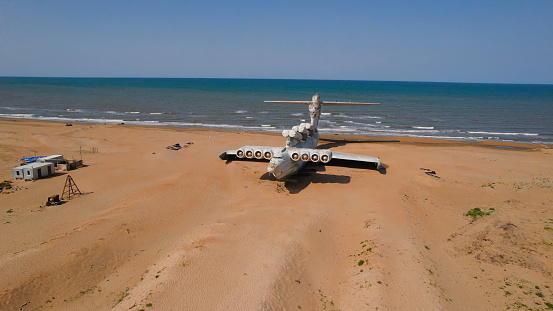 Old plane on beach. Action. Military plane landed on coast of sea many years ago. Abandoned military plane on seashore with history.