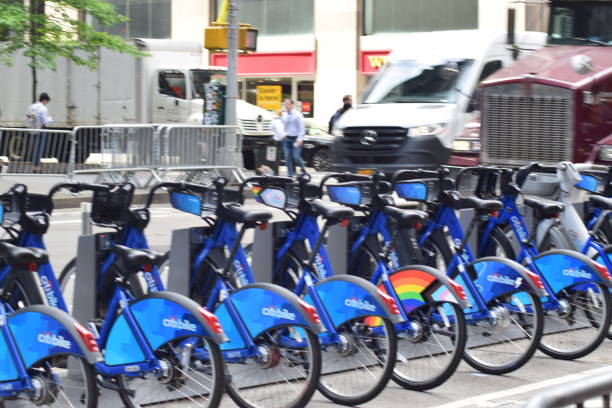 Row of Citi Bikes in Manhattan New York, NY USA - June 9, 2022: New York City, Citi Bikes Docked on Sixth Avenue in Midtown Manhattan bicycle docking station stock pictures, royalty-free photos & images