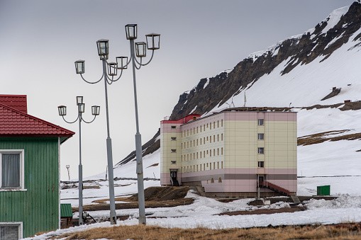 Landscape of the Russian city of Barentsburg on the Spitsbergen archipelago in the winter in the Arctic. In sunny weather and cloudy sky.