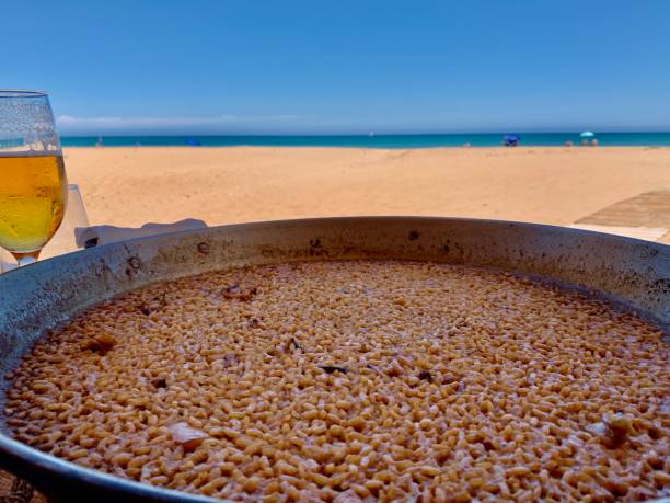 arroz a banda, типичная валенсийская еда, приготовленная из риса и морепродуктов, похожая на паэлью. - beer food paella clam стоковые фото и изображения