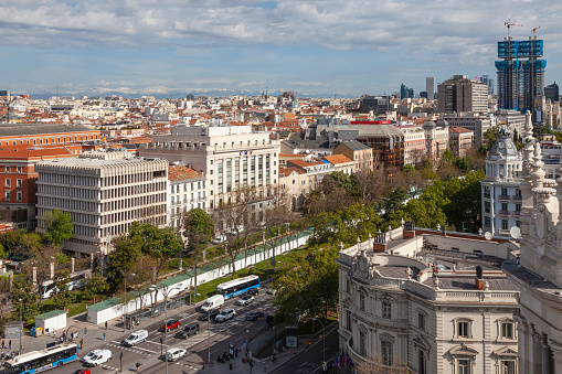 Madrid, Spain - 26th April 2022. Elevated view of part of central Madrid with part of the Palace of Cibeles left front, and behind it, the Paseo de Recoletos. The Torres de Colon, under refurbishment, are top right.