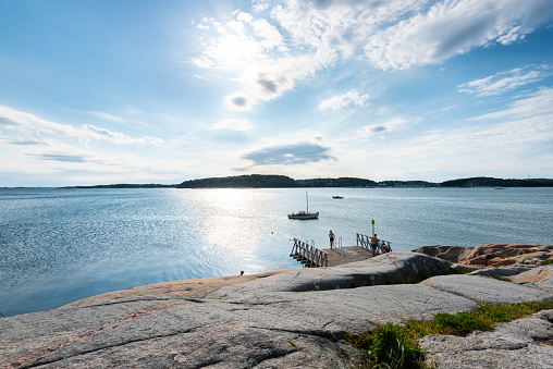 Gothenburg, Sweden - June 12 2020: Motorboats passing cliffs and a bathing platform in summer.