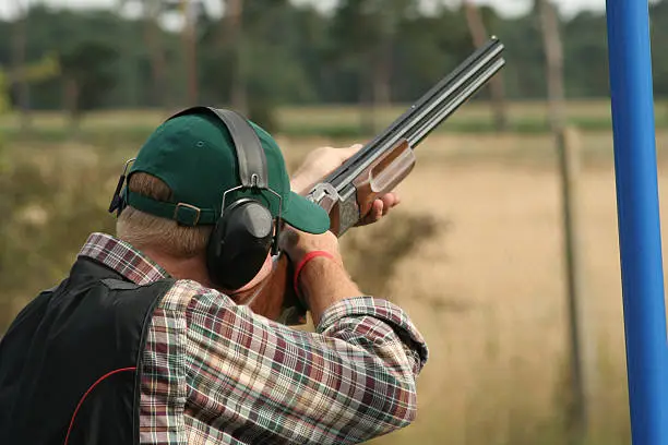 Photo of A male clay shooter holding a gun at his shoulder